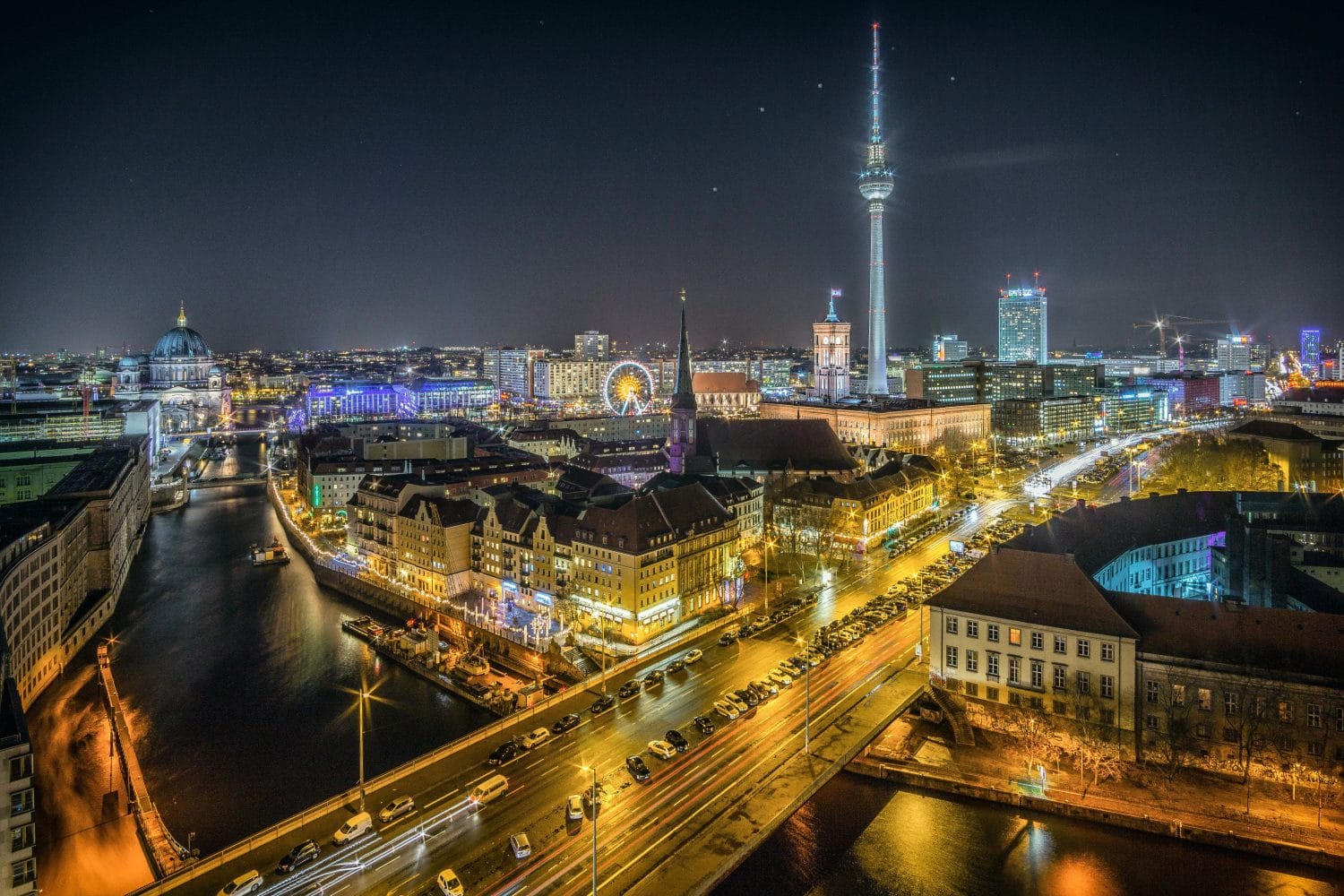 View over the River Spree to Nikolaiviertel and Alexanderplatz. The Nikolaiviertel is the reconstructed historical heart of the German capital Berlin. The Nikolaikirche (Saint Nicholas Church) gives its name to the neighbourhood five minutes away from Alexanderplatz. The Alexanderplatz is a large public square and transport hub in the central Mitte district of Berlin, near the Fernsehturm the Rotes Rathaus, the town hall of Berlin.